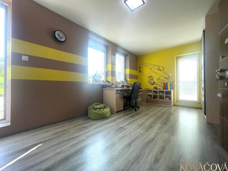 Children's room in a family house with a wooden decor floor and yellow stripes on the walls.