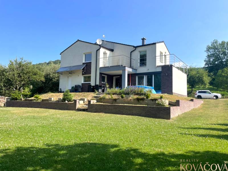 Family house in Melčice-Lieskové with a landscaped garden and parking on a grassy plot.