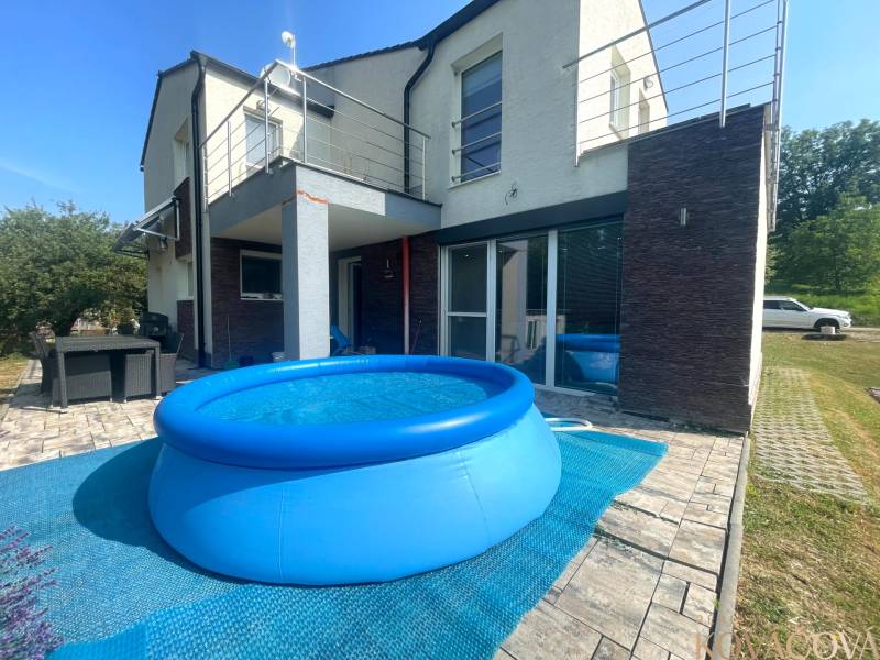 A family house in Melčice-Lieskové with a swimming pool and a terrace with rattan furniture.