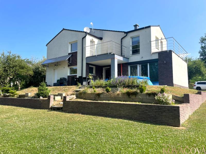 A family house in Melčice-Lieskové with a garden and terrace; grassy area with flowers.
