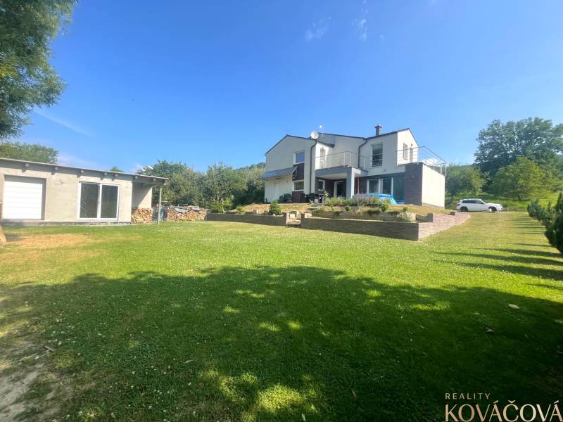 Family house in Melčice-Lieskové, large garden, garage, blue sky, summer day.