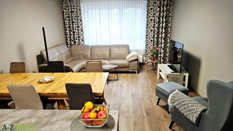 Living room in a 3-room apartment with a leather sofa and a wooden decor floor.