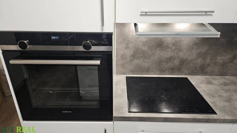 A kitchen unit with a cooktop and an oven in a 3-room apartment.