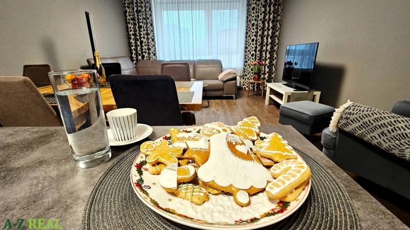 Living room in a three-room apartment with cookies on a plate and a wooden decor floor.