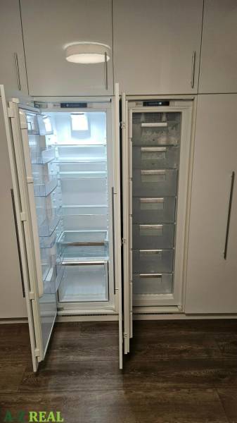 Refrigerator and freezer with wooden floor decor in a 3-room apartment.