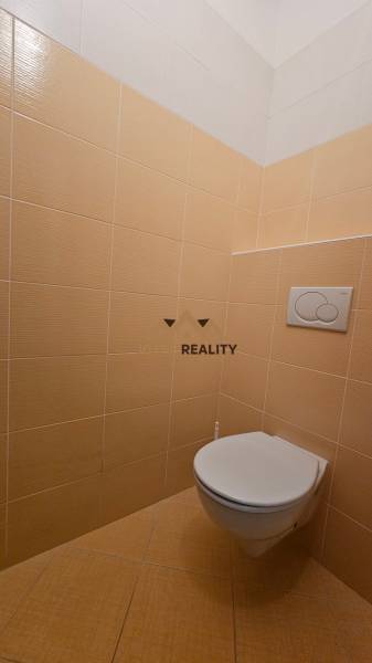 A restroom with beige tiles in commercial premises.