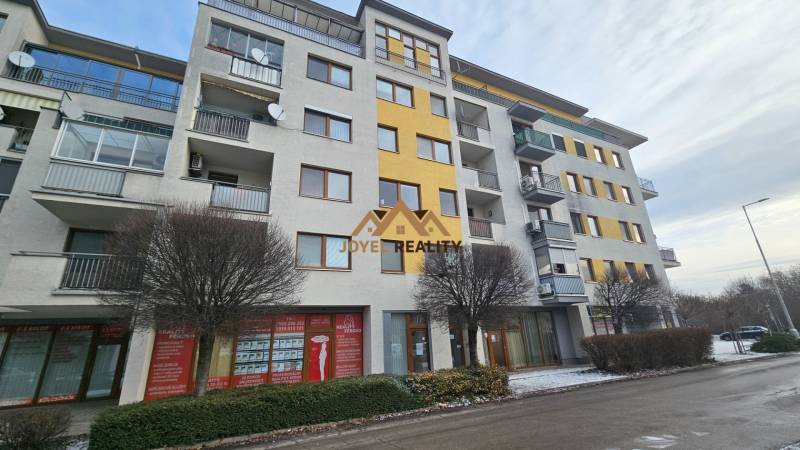 A building with commercial spaces on Budovateľská Street in Šaľa with a winter touch.