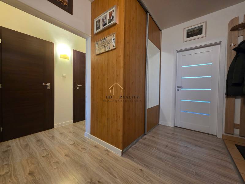 Interior of a 3-room apartment with a wooden decor floor and a built-in wardrobe.