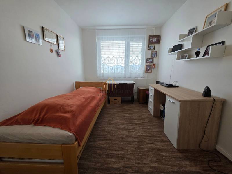 A simply furnished bedroom or study in a 3-room apartment with a bed and a desk.