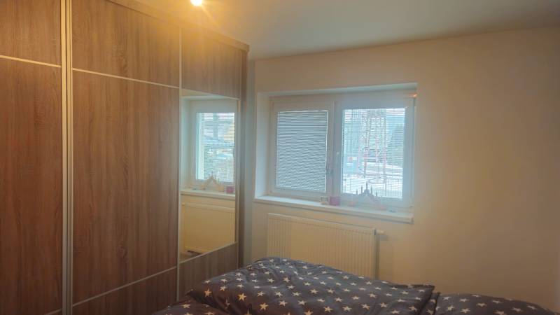 Bedroom in a family house with a large wardrobe and a bed with star-patterned bedding.