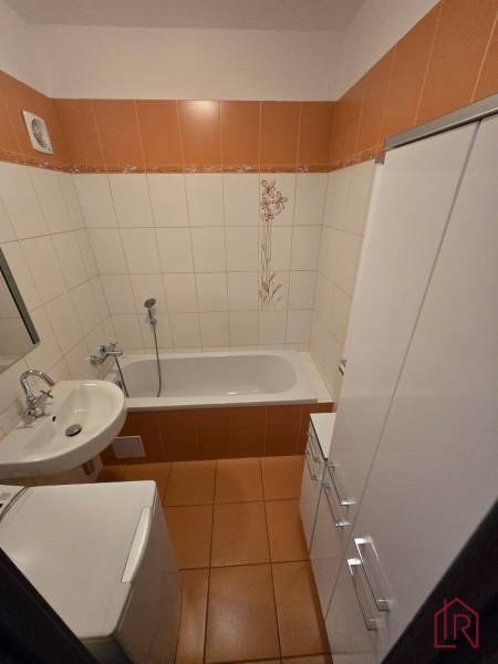 Bathroom in a 3-room apartment with a bathtub and orange tiles.