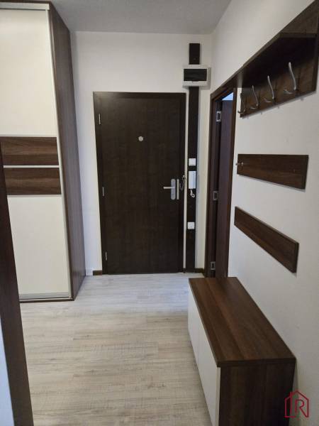 Entrance hall with wood-patterned flooring, storage space, and a coat rack wall in a 3-room apartment.