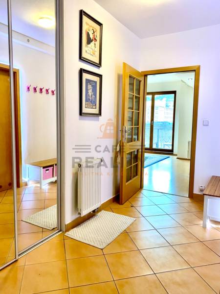 Hallway in a 2-room apartment with terracotta tiles and a mirrored wardrobe.