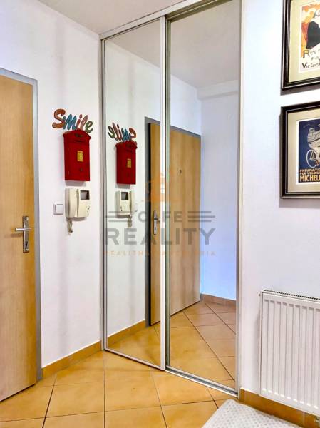A hallway with tiles, a built-in wardrobe, and a mailbox in a 2-room apartment.