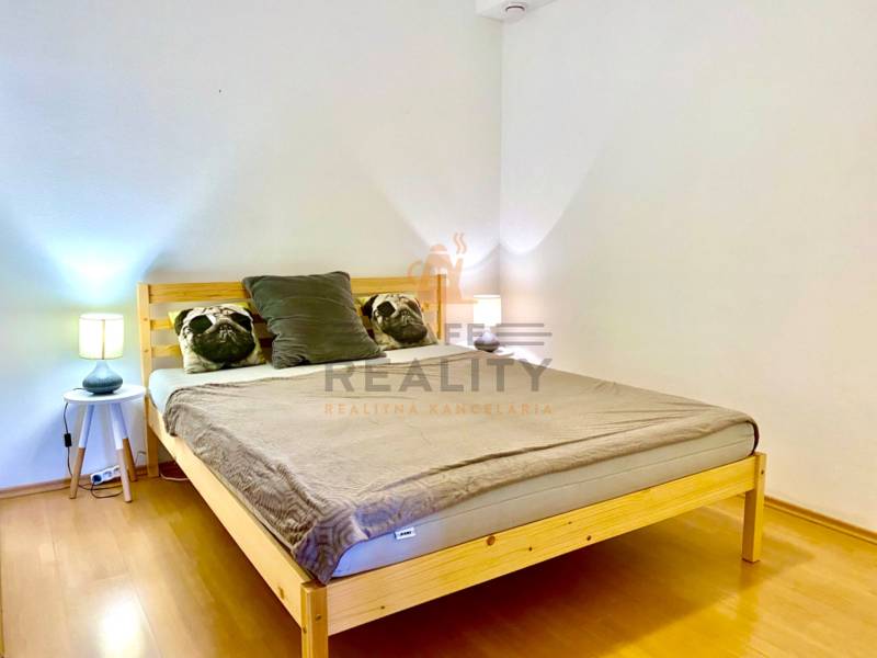 Bedroom in a 2-room apartment with wooden decor and pillows on the bed.
