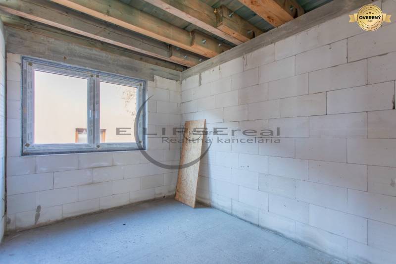 A building with white walls and a large window opening in the building.