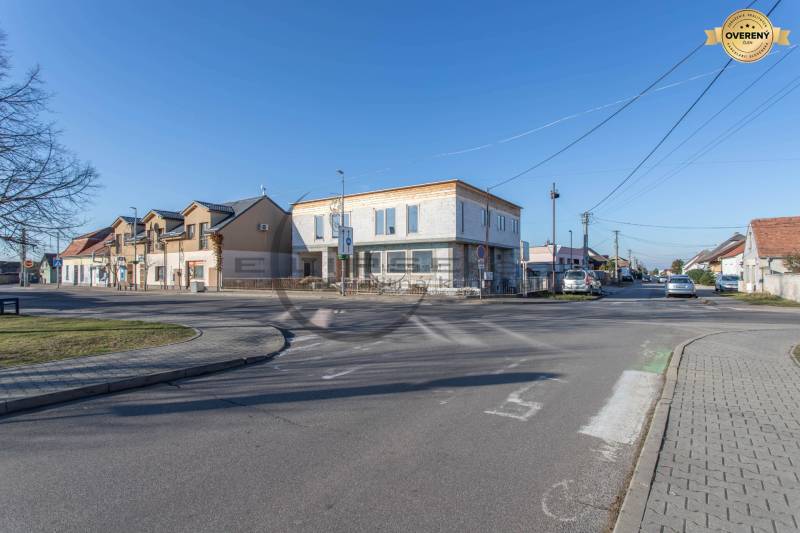 A road and a building in the center of the village Veľké Leváre on a sunny day.