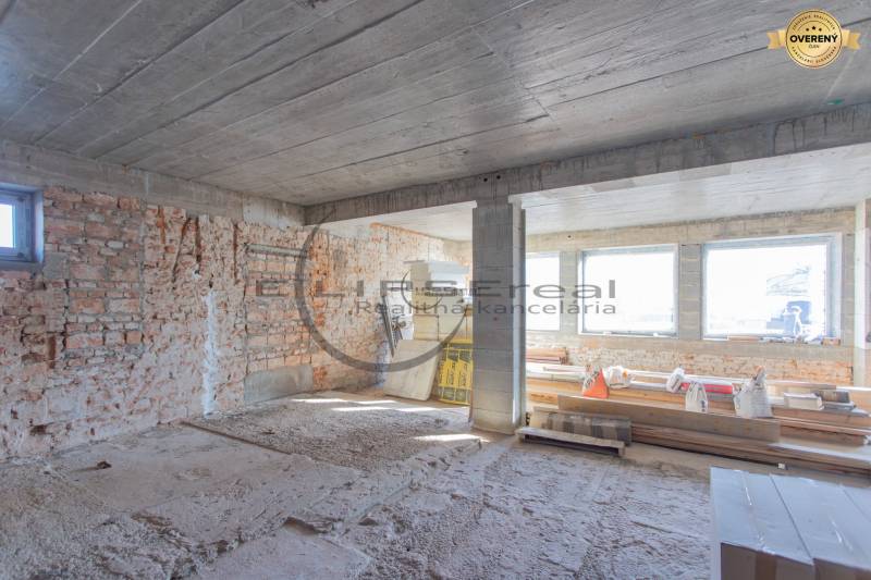 Construction site in a building with brick walls and large windows. The construction is in progress.