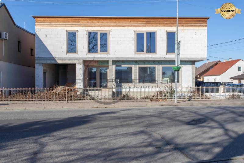 A building in Veľké Leváre with an unfinished facade standing by the road.