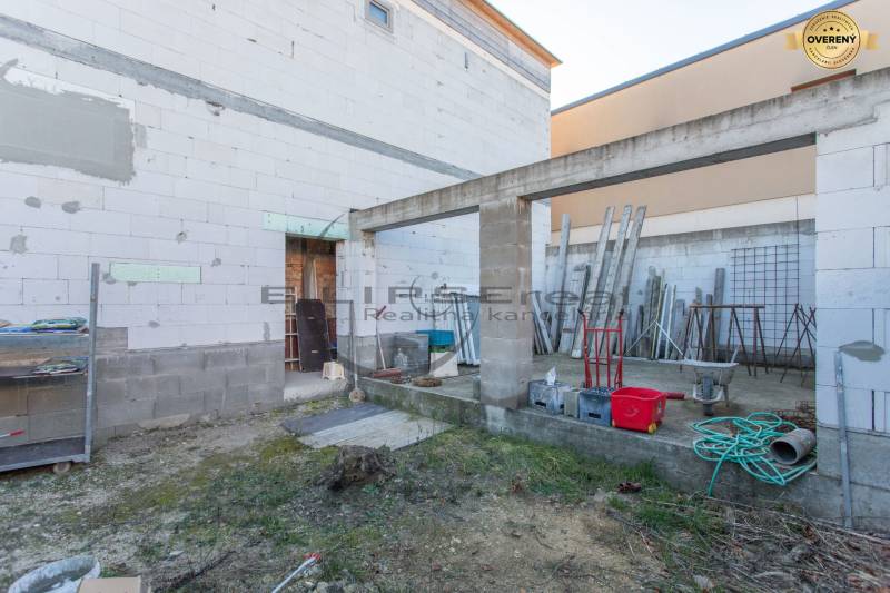 Construction site in Veľké Leváre with materials and tools near a building made of concrete blocks.