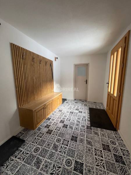 A hallway in a family house with colorful tiles and wooden elements.