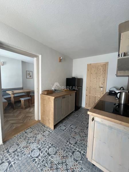 Kitchen in a family house with colorful tiles, wooden decor, and entrance to the dining room.