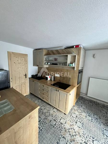 A kitchen in a family house with a kitchen unit, floor with a decorative pattern.