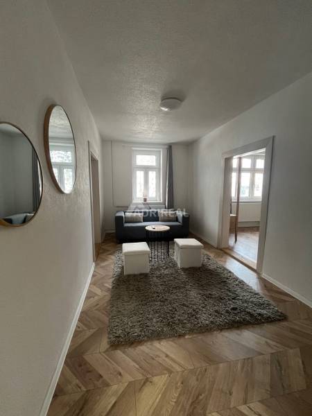 Living room in a family house with a wooden decor floor and comfortable seating.