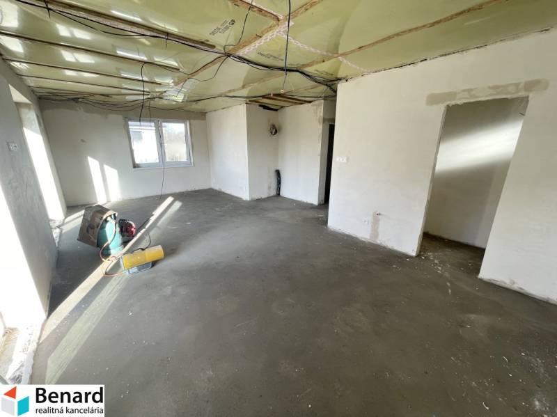 The interior of a family house with an unfinished floor and an unfinished ceiling.
