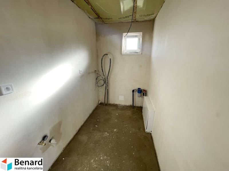 An empty room with a window in a family house, visible installations and preparation for furnishing.