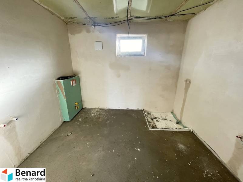 An unfinished room in a family house, with installation preparation and exposed walls.