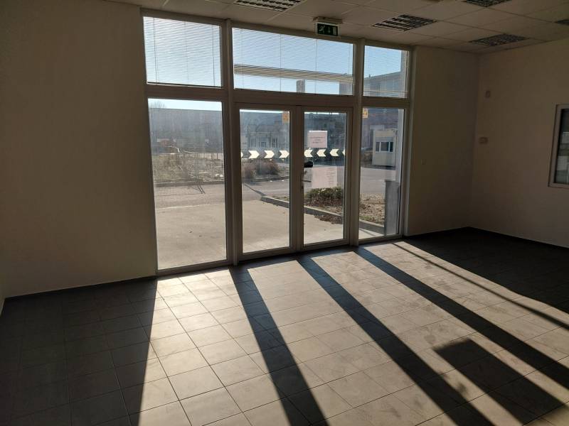 Spacious interior with large windows and tiled flooring in warehouses and halls.