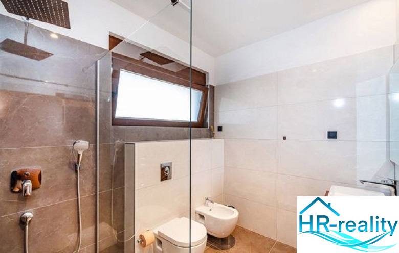 Bathroom in a villa with a glass-enclosed shower and modern sanitary equipment.