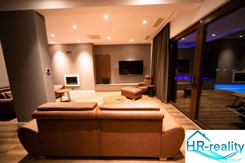 Living room in a villa with a leather sofa and a wooden decor floor.