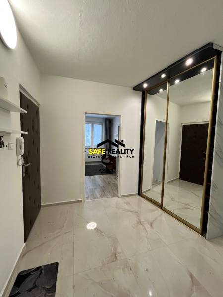 A hallway in a 3-room apartment with a polished floor and a built-in wardrobe.