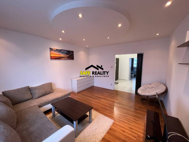 Living room in a 3-room apartment with a comfortable sofa and a floor with a wooden design.