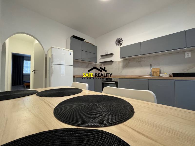A kitchen in a 3-room apartment with a simple design and a dining table with placemats.
