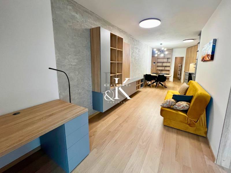 Living room in a two-room apartment with a wooden decor floor and furniture.