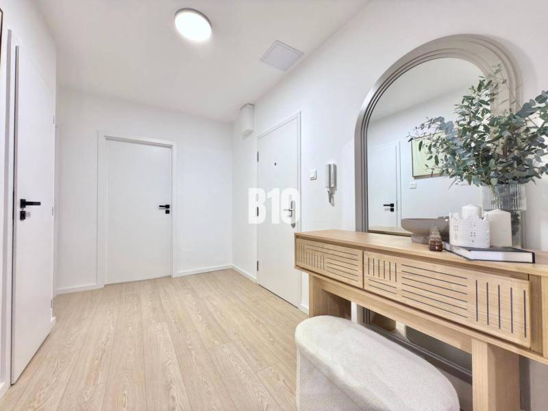 Entrance hall in a 3-room apartment, with a mirror, wooden decor, and decorations.