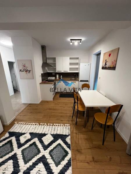 Kitchen space in a 2-room apartment on Brečtanová Street with wooden elements and decorations.