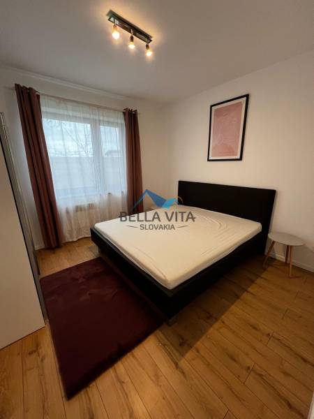 Bedroom in a 2-room apartment on Brečtanová Street with a bed, picture, and light.