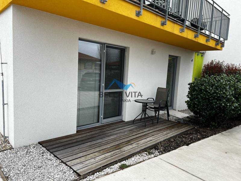 On Brečtanová Street, there is a terrace of a 2-room apartment with seating by the garden.