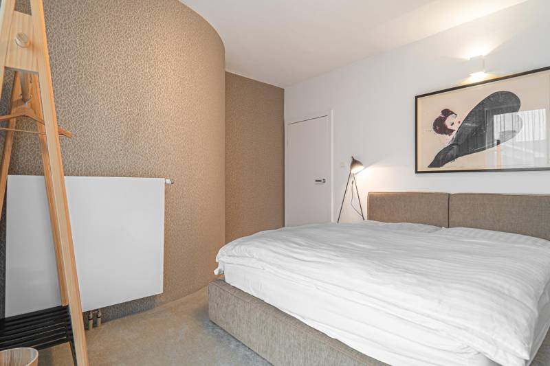 Bedroom in a 4-room apartment, with decorative wallpaper and art on the wall.