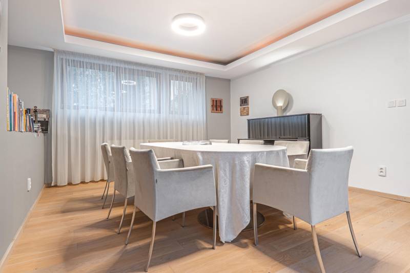 Dining room in a 4-room apartment with a wooden decor floor and light curtains.