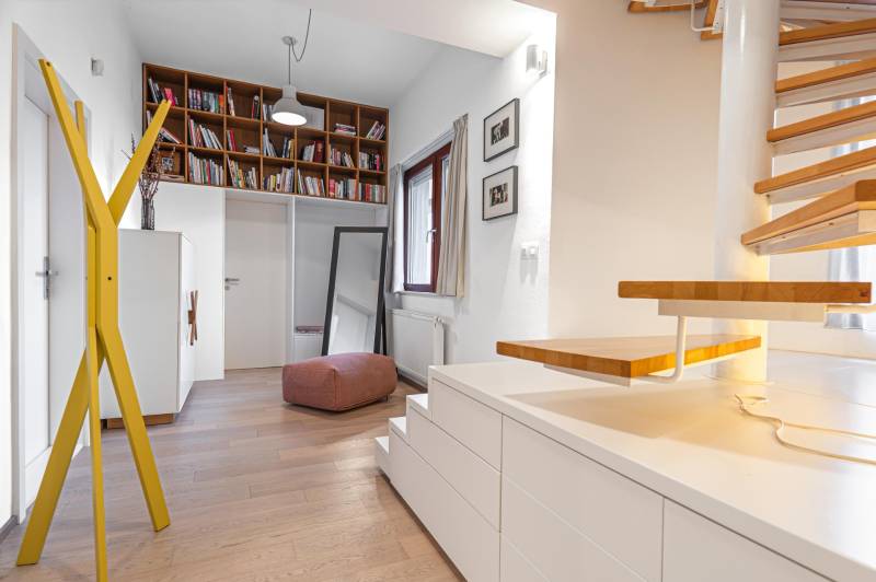 Interior of a 4-room apartment with shelves, stairs, and flooring with a wood decor.