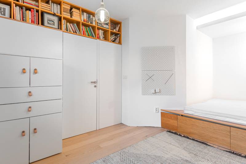 Interior of a 4-room apartment with bookshelves, built-in wardrobes, and flooring with a wood decor.