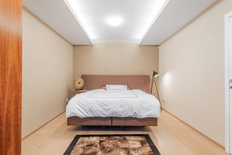 Bedroom in a 4-room apartment with hallway lighting and flooring with a wooden decor.