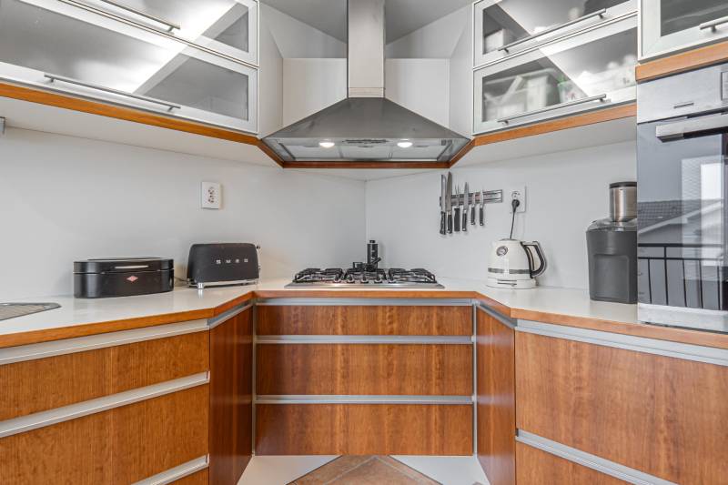 A kitchen in a 4-room apartment with a stainless steel extractor hood and appliances.