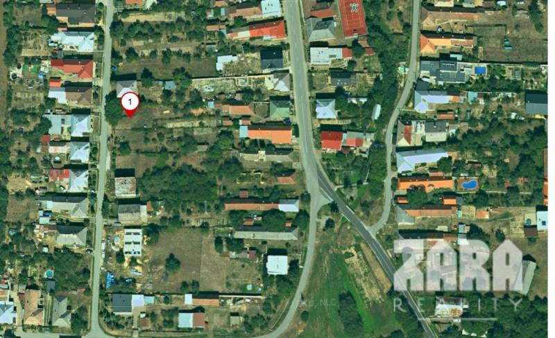 Aerial view of plots - housing in Nováčany with scattered development and greenery.