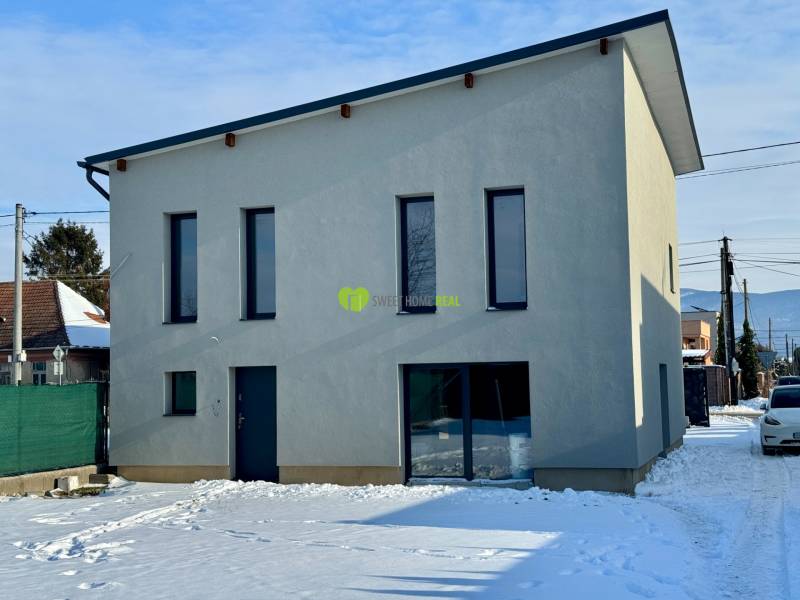 A family house on Gyňovská Street in Čaňa with a snow-covered yard and a minimalist facade.